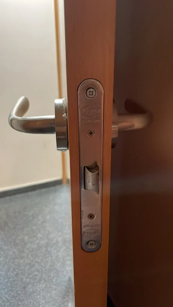 Cerradura embutida instalada en el canto de una puerta de madera