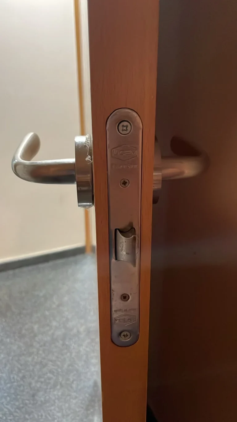 Cerradura embutida instalada en el canto de una puerta de madera