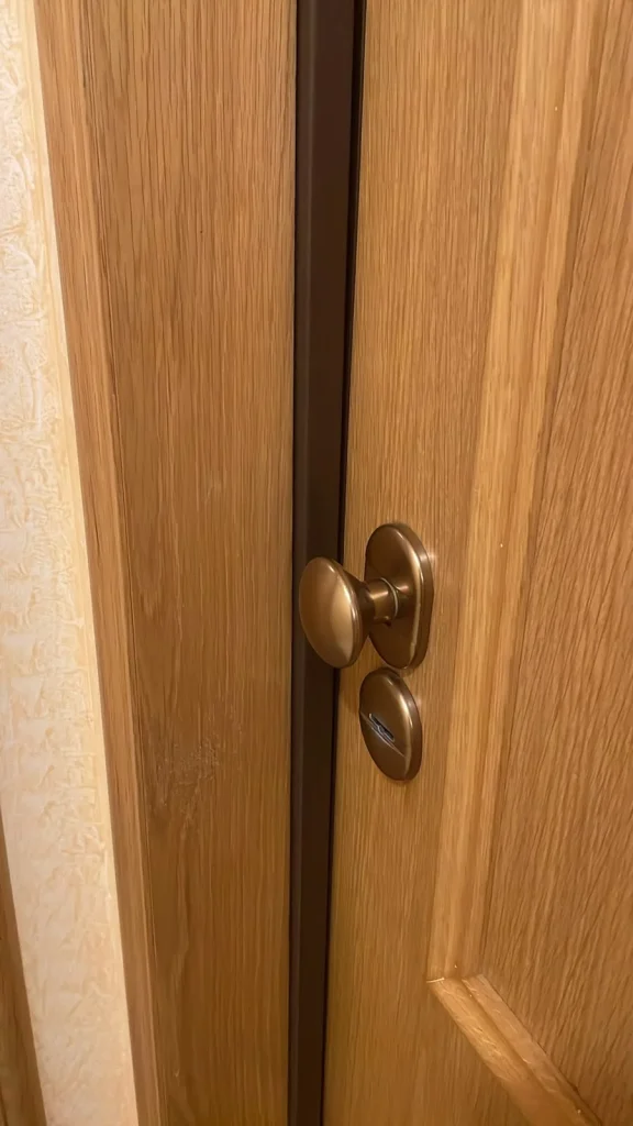 Puerta de madera de roble con pomo y escudo de seguridad