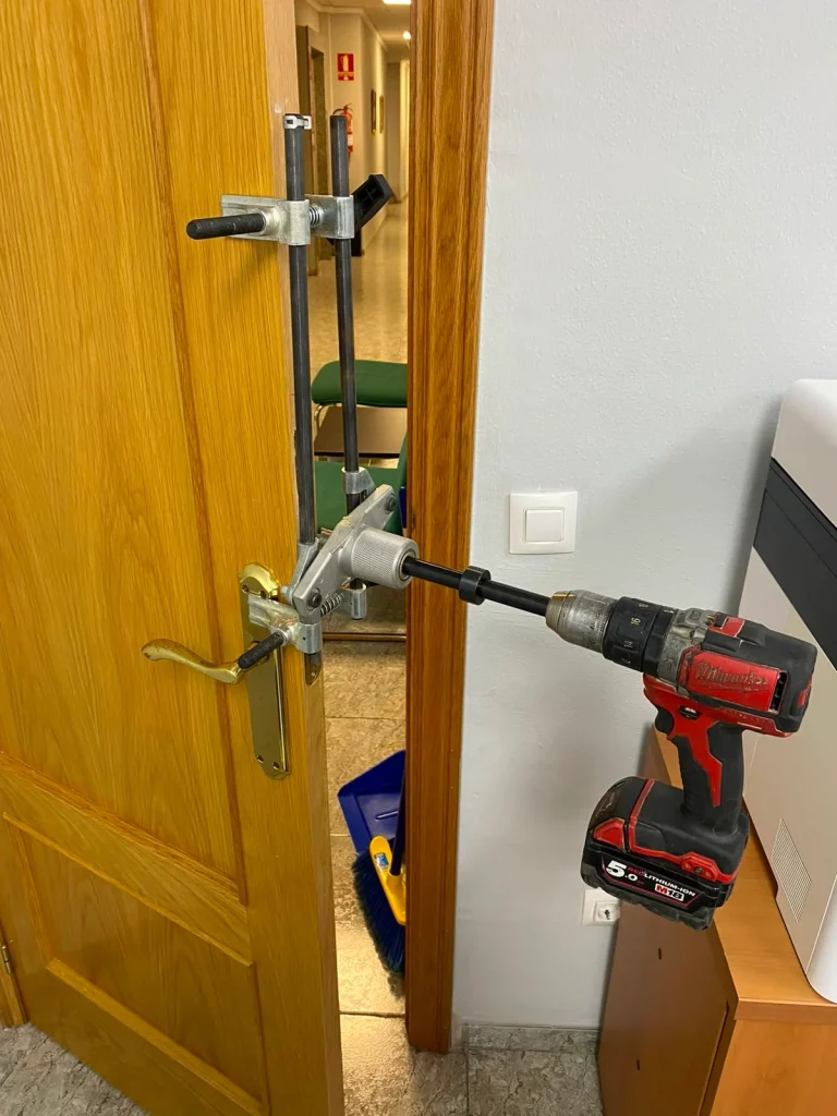 Cerrajero abriendo una puerta con un extractor de cilindro y taladro